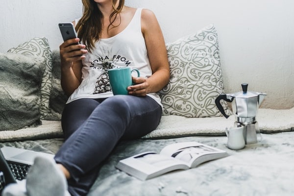 自宅でスマホを触る女性の画像